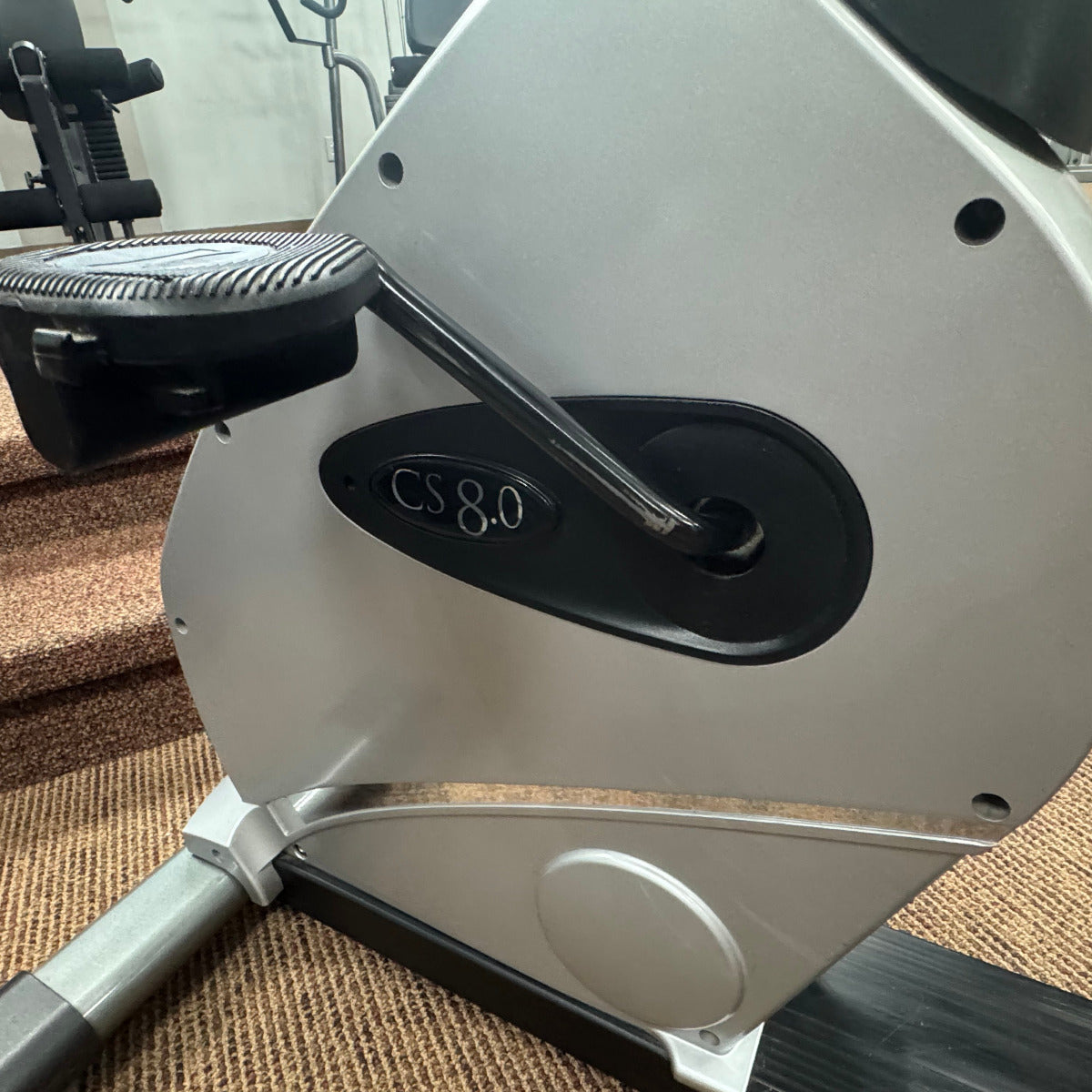 Exercise bike with a visible brand logo on a carpeted floor