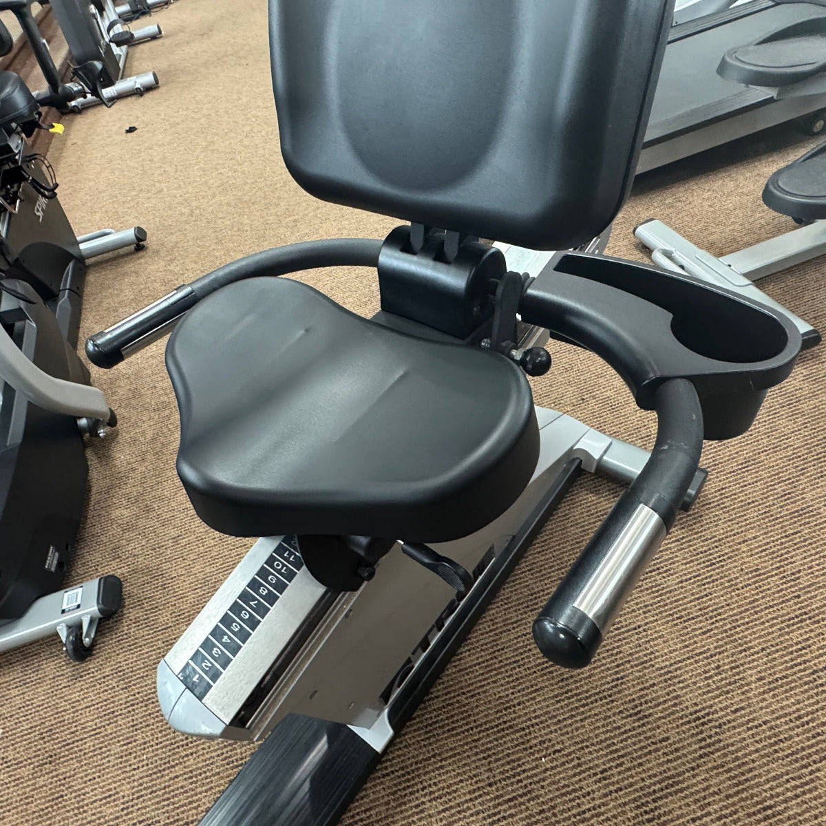 Exercise bike with a cup holder on a brown carpeted floor
