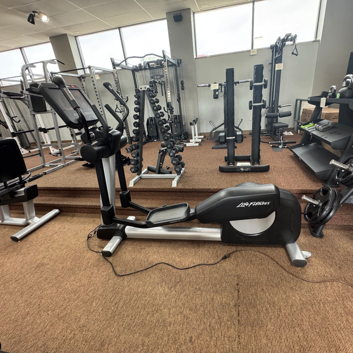 Gym interior with cardio equipment and weight machines.