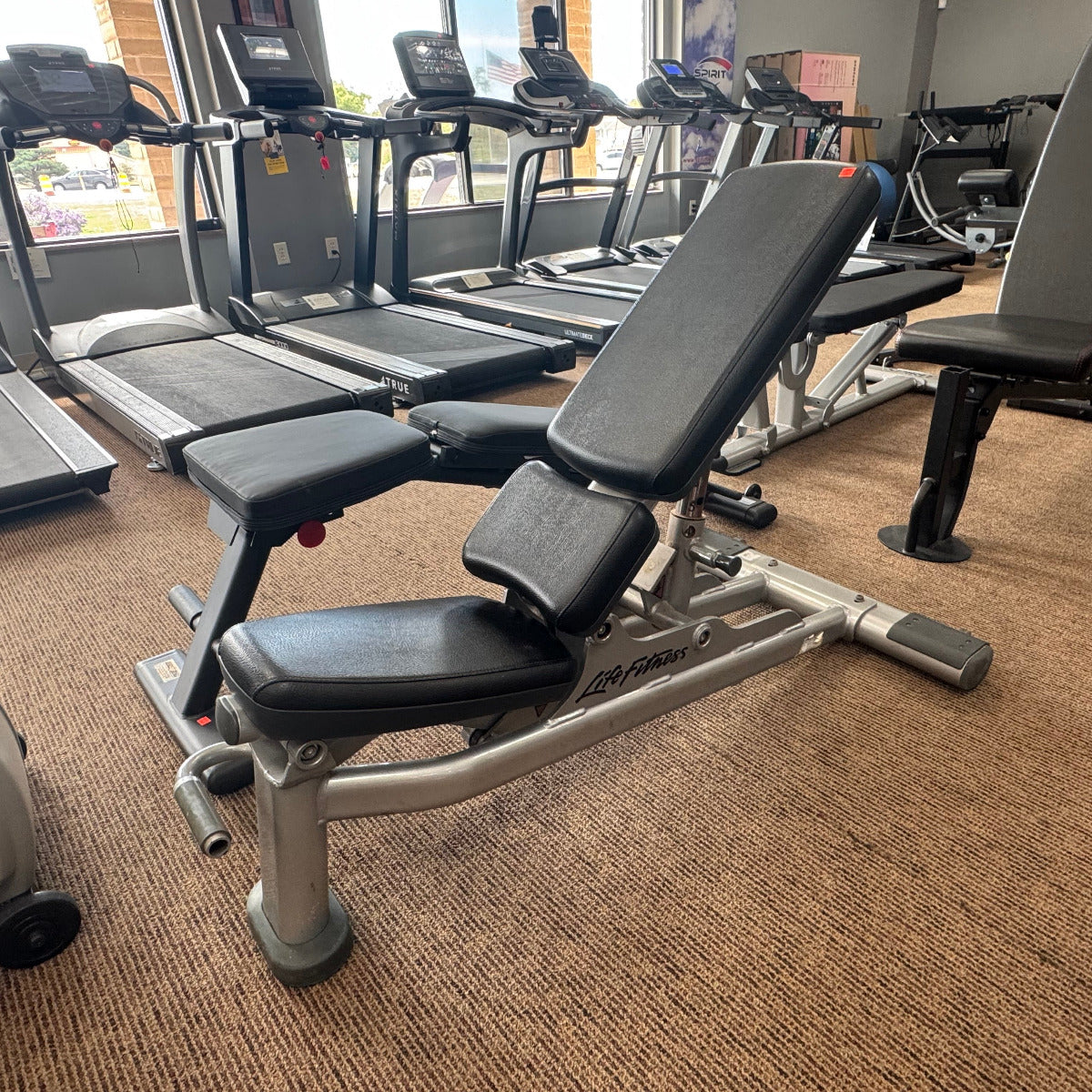 Gym bench in a fitness center with treadmills in the background