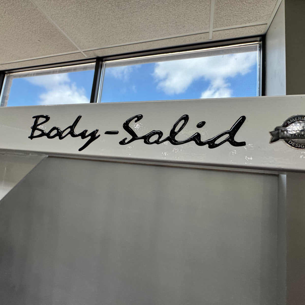 Body-Solid slogo in the background showing blue sky and clouds.