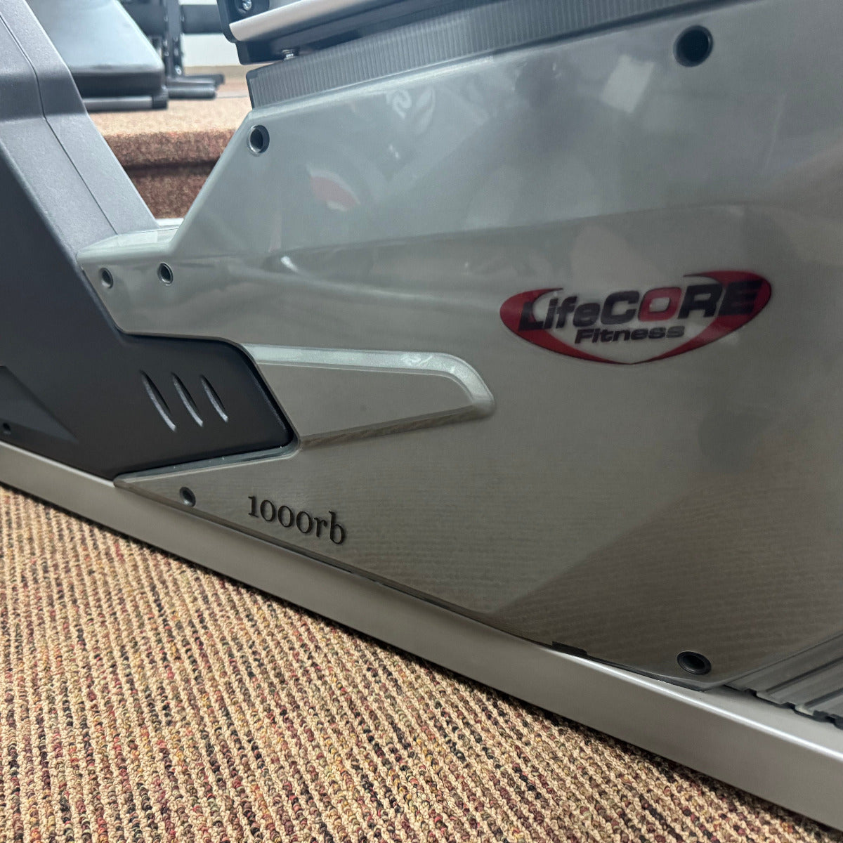 Exercise bike with 'Lifecore Fitness' branding on a carpeted floor