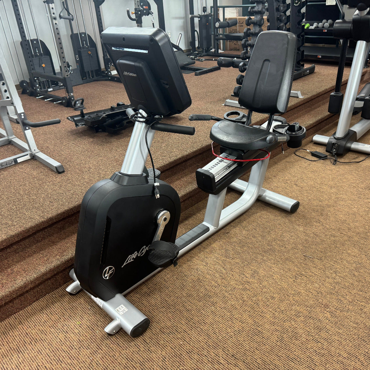 Exercise bike in a gym setting with various equipment in the background