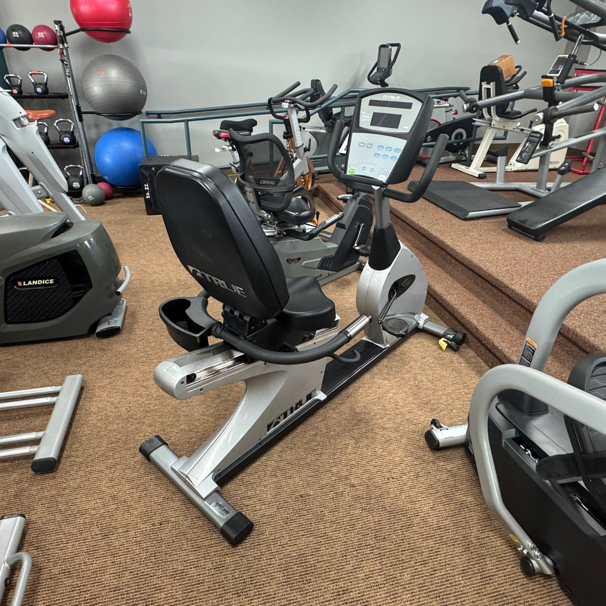 Gym interior with various exercise equipment including stationary bikes and treadmills.